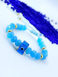 Pulsera con ojo turco Cuadrado cristales celestes y balines dorados good luck